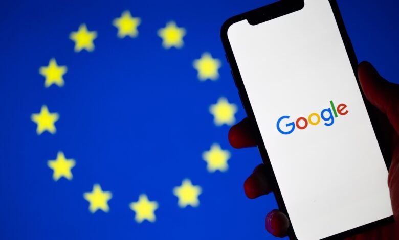 Google logo on phone screen with EU flag in background.