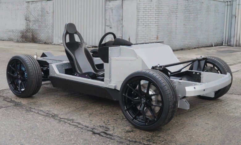 Exposed chassis of a sports car with seat and wheels.