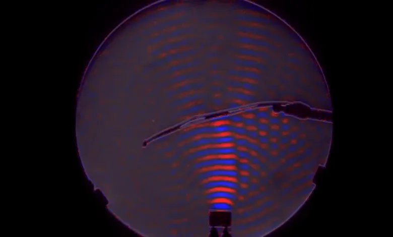 Visual representation of sound waves using a specialized camera, showing red and blue interference patterns.
