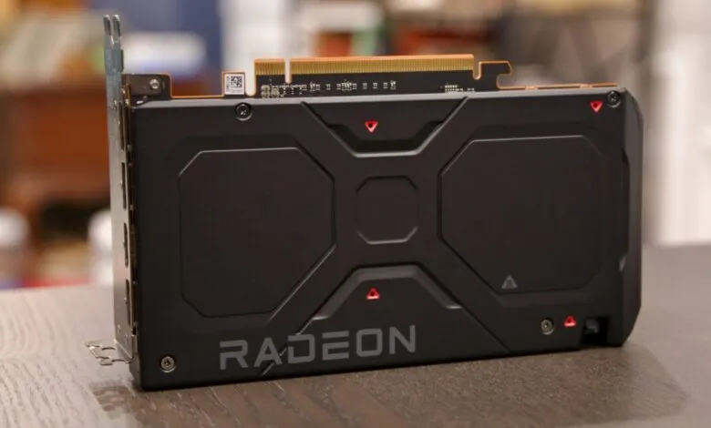 Close-up of a black AMD Radeon graphics card on a wooden surface.