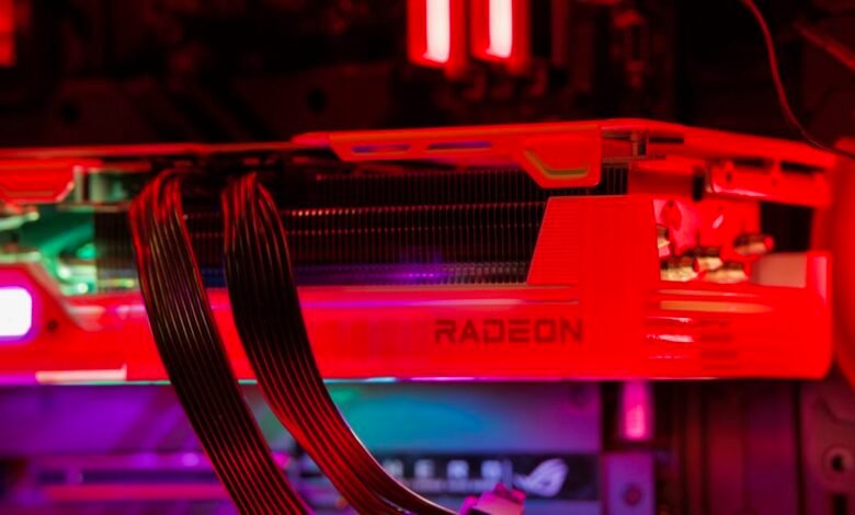 Close-up of a Radeon graphics card inside a computer case with red and purple lighting.