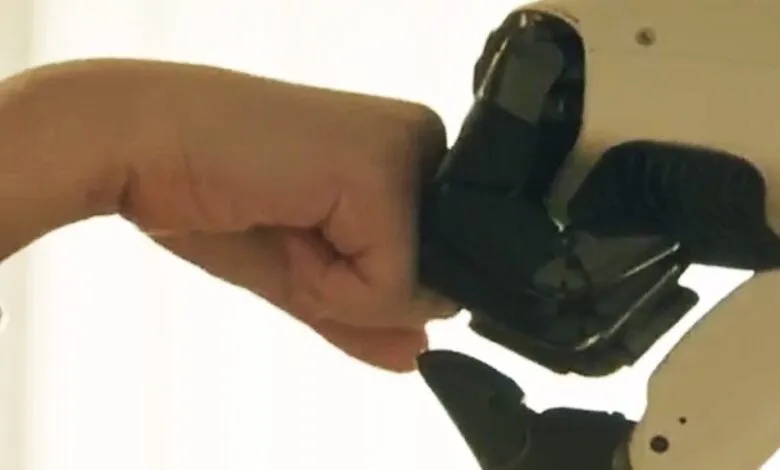 Human fist bumps a white robot hand in a gesture of connection.