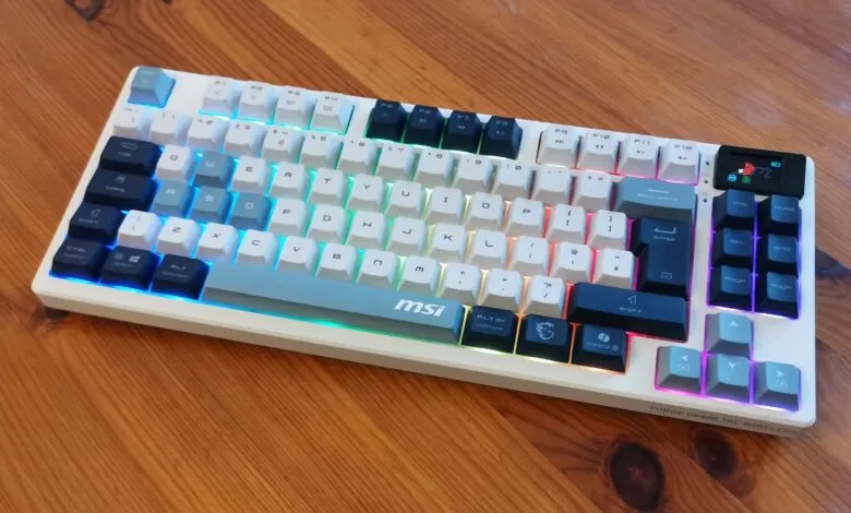 MSI Forge GK600 TKL Wireless keyboard with RGB lighting on wood surface.