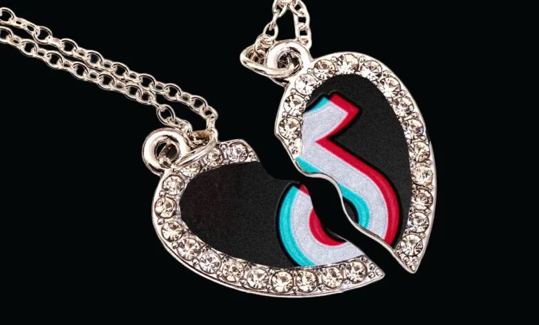 Broken heart necklace with TikTok logo, symbolizing social media breakup.
