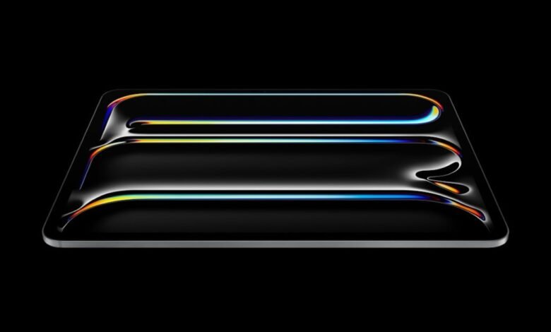 Sleek, black tablet with iridescent light reflections on a dark background.