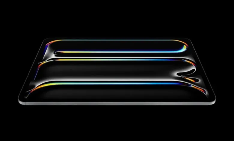 Sleek, black tablet with iridescent light reflections on a dark background.