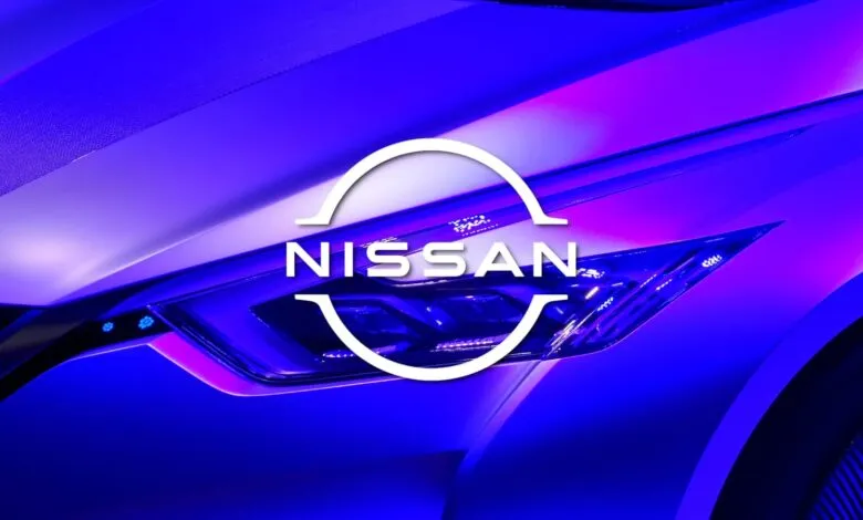 Close-up of a Nissan car headlight with the Nissan logo overlayed.