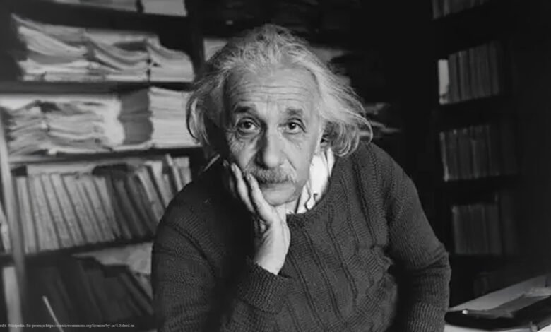 Black and white portrait of Albert Einstein with hand on his face.