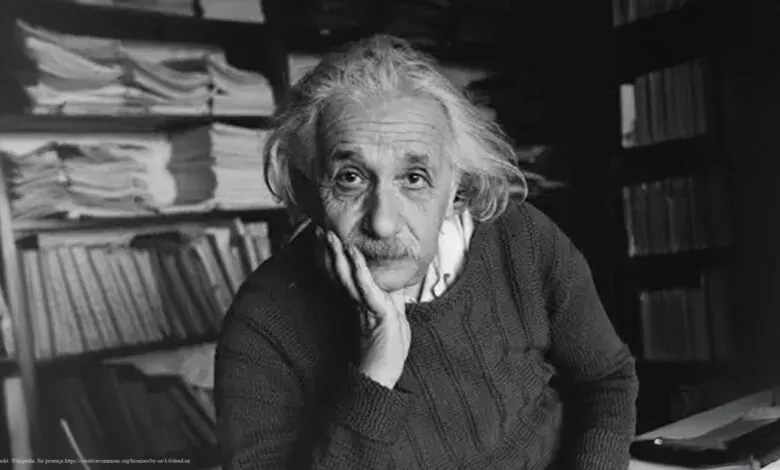 Black and white portrait of Albert Einstein with hand on his face.