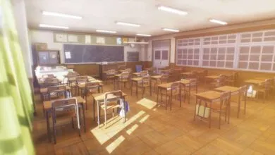 Empty classroom with desks, chairs, blackboard, and bright sunlight.