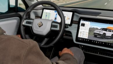 Interior view of Rivian electric vehicle showing dashboard screens and steering wheel.