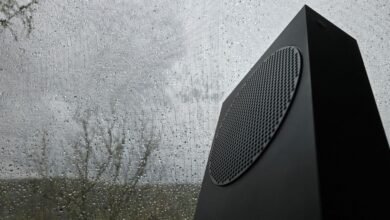 Xbox Series X console against a rainy window, moody lighting.