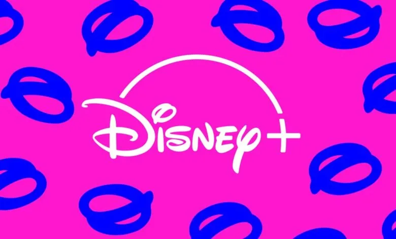 Disney+ logo in white on a pink background with blue Mickey Mouse head pattern.