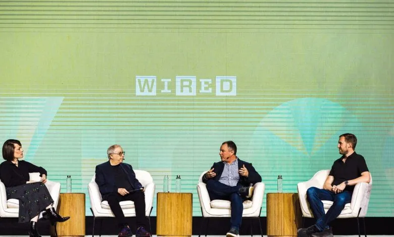Four people sit on stage at a Wired event, engaging in a panel discussion.