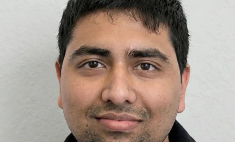 Close-up portrait of a man with dark hair and brown eyes.