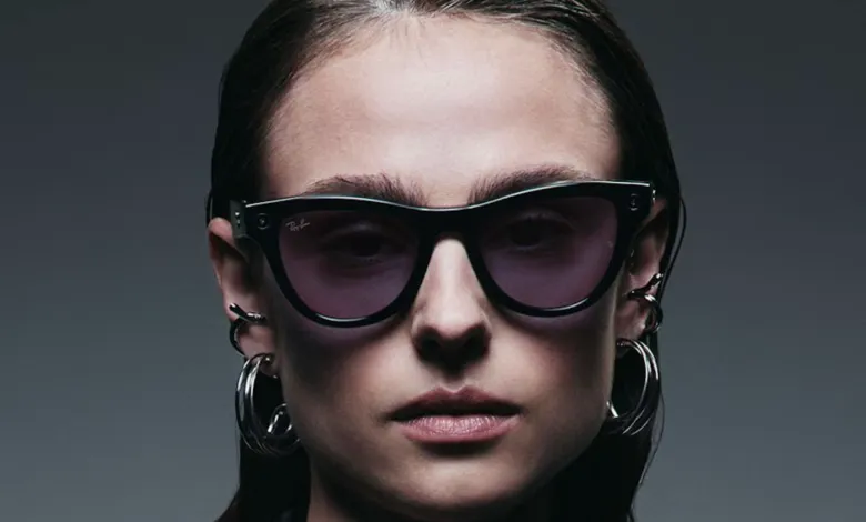 Close-up of a woman wearing black Ray-Ban sunglasses and silver hoop earrings.