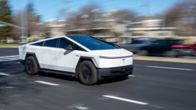 White Tesla Cybertruck driving on road with blurred background.