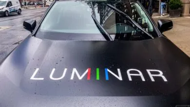Luminar car hood with logo, windshield wipers, and raindrops.