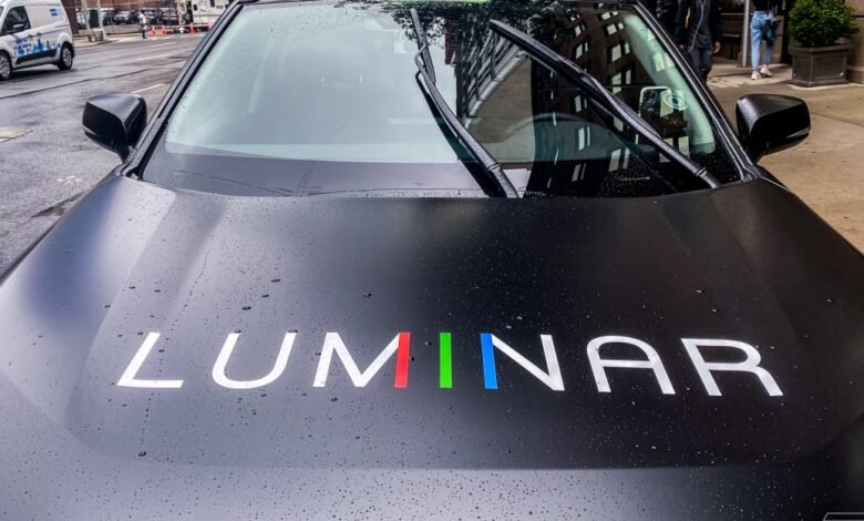 Luminar car hood with logo, windshield wipers, and raindrops.