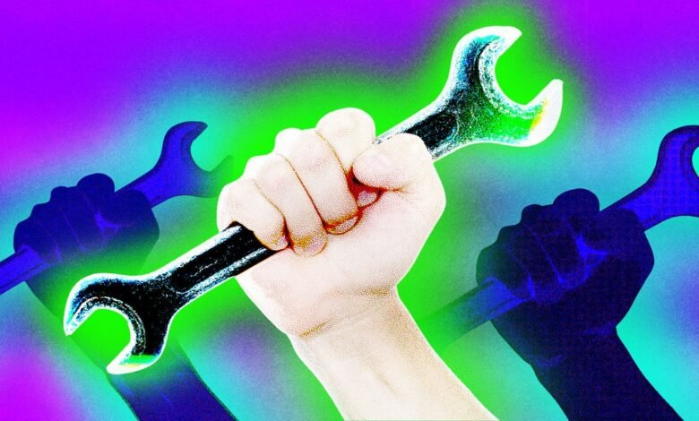 Hand holding a wrench with two blurred wrenches in the background.