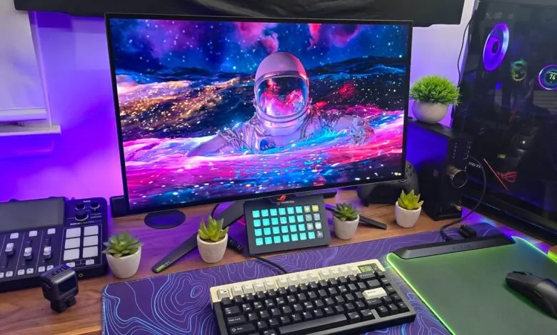 Gaming setup with monitor displaying astronaut in colorful water and space.