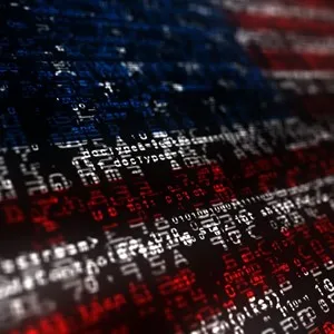 American flag overlaid with lines of computer code in red, white, and blue.