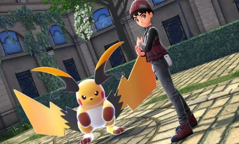 Pokémon trainer stands with Alolan Raichu in a park setting.
