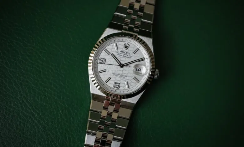 Close-up of a Rolex Oyster Perpetual Land-Dweller watch with a silver honeycomb dial and jubilee bracelet.
