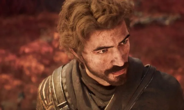 Close-up of a man with blonde hair and a beard, looking off to the side.