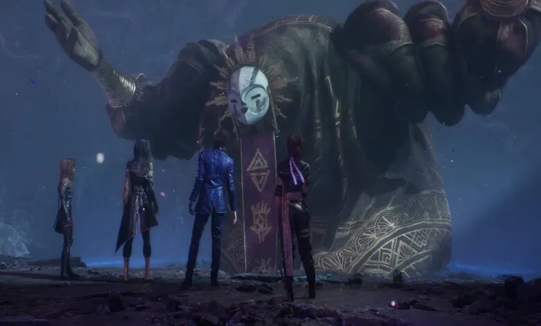 Four figures stand before a colossal statue with a mask in a dark, mystical setting.