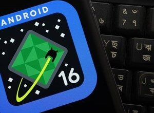 Android 16 game icon displayed on a phone screen next to a keyboard.