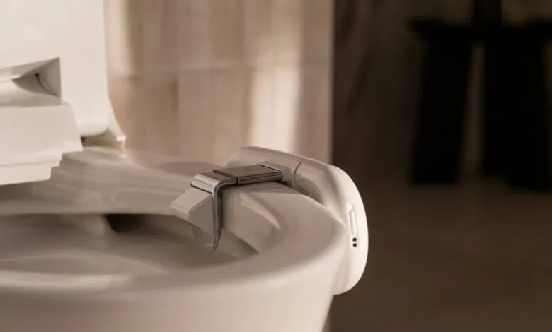 Close-up of a white Dekoda bidet toilet seat with chrome accents.
