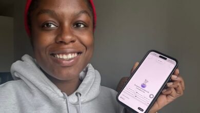 Smiling woman shows a productivity app on her phone.