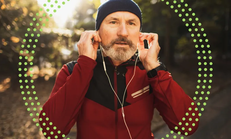 Man with beard puts in earbuds before outdoor run.