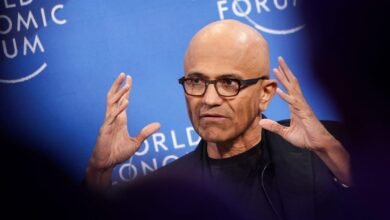 Satya Nadella speaking at the World Economic Forum, gesturing with his hands.