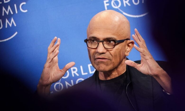 Satya Nadella speaking at the World Economic Forum, gesturing with his hands.
