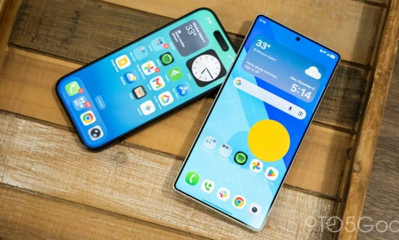 Two smartphones, one iPhone and one Android, display home screens on a wooden tray.