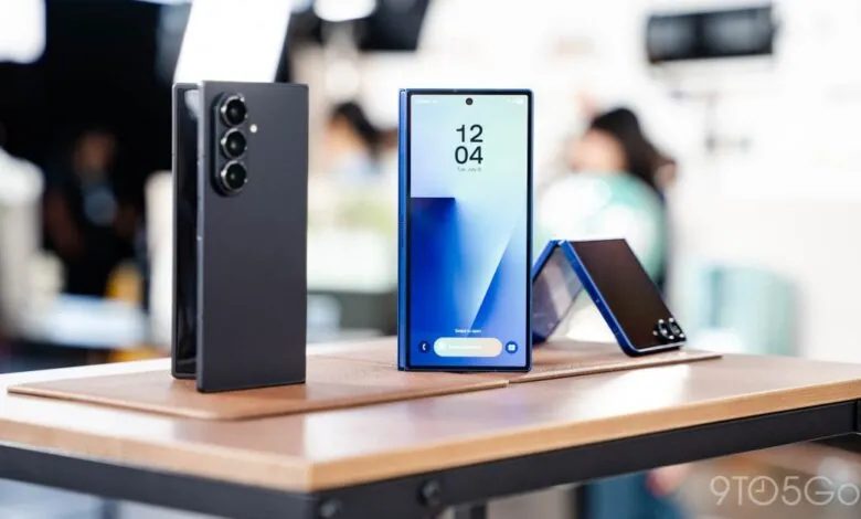 Three foldable phones on a table, one open showing the screen.