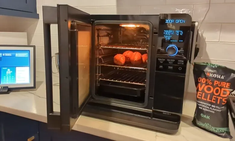 Indoor smoker with food inside, bag of wood pellets nearby.