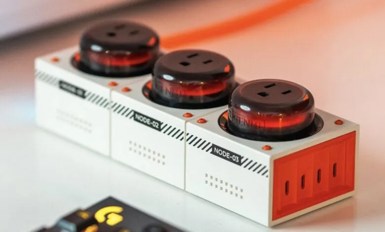 Three-outlet power strip with retro-futuristic design on a white surface.