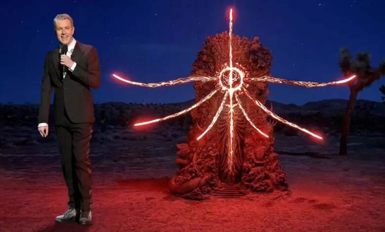 Geoff Keighley stands next to a glowing, otherworldly statue in the desert.
