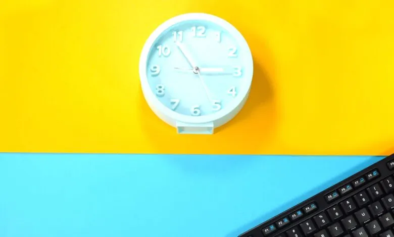 Light blue clock and keyboard on a split yellow and blue background.