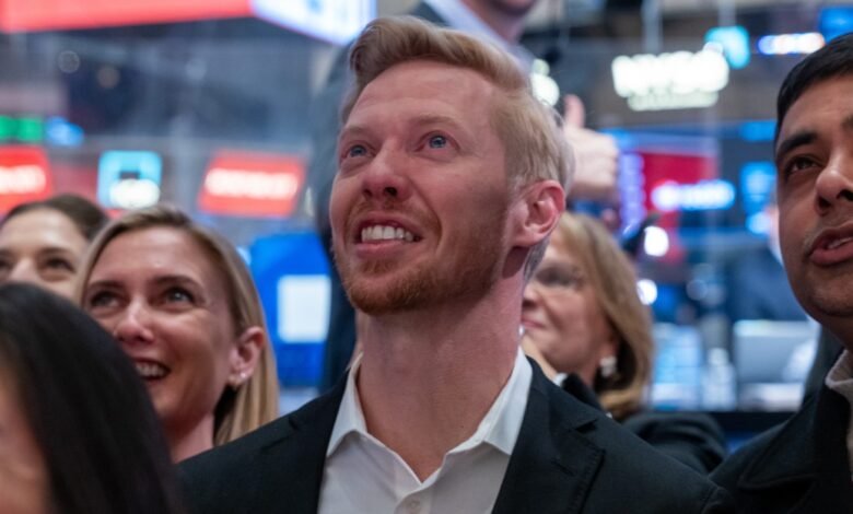 Group of people looking up at the New York Stock Exchange trading floor.