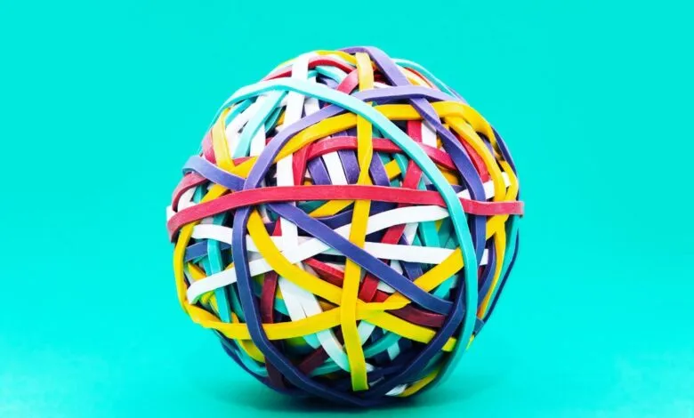 Colorful rubber band ball on a bright turquoise background.