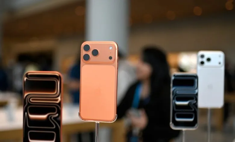 Close-up of new iPhones on display, showcasing camera and color options.
