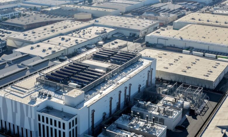 Aerial view of industrial buildings with solar panels on a rooftop.