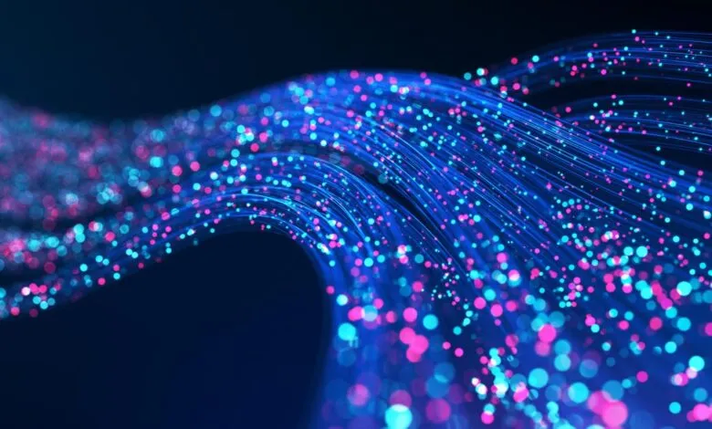 Abstract blue and pink light streaks on dark background.