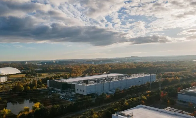 Aerial view of a large data center complex surrounded by trees and buildings.