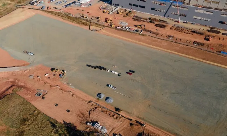 Aerial view of a construction site with heavy machinery and building materials.