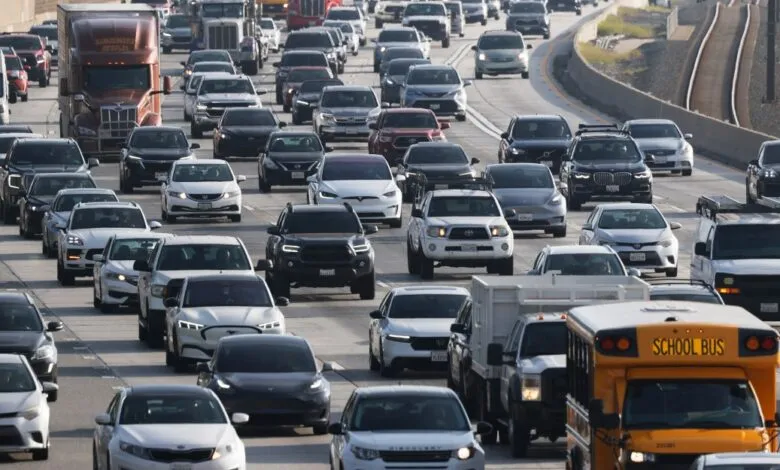 Heavy traffic on a multi-lane highway with cars, trucks, and a school bus.